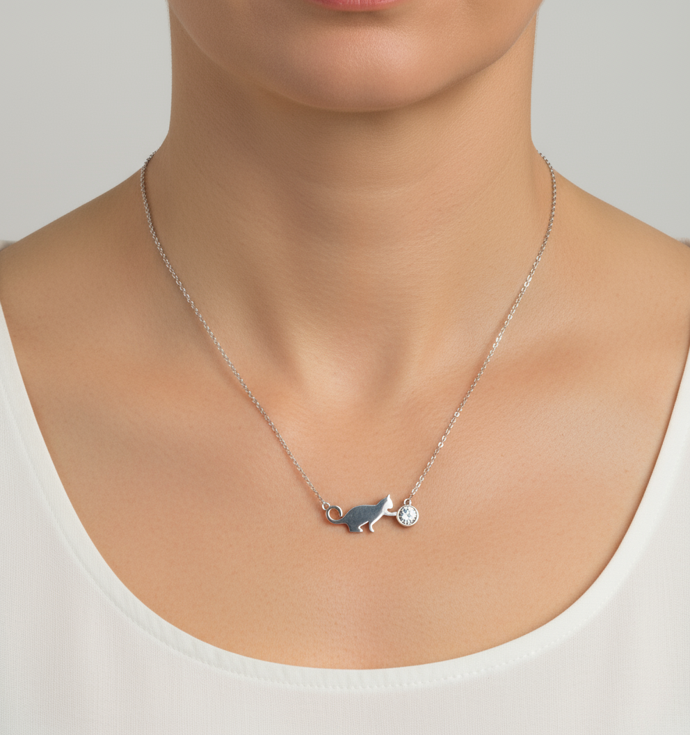 Mulher de 40 anos usando colar de prata com silhueta de gato e brilhante.