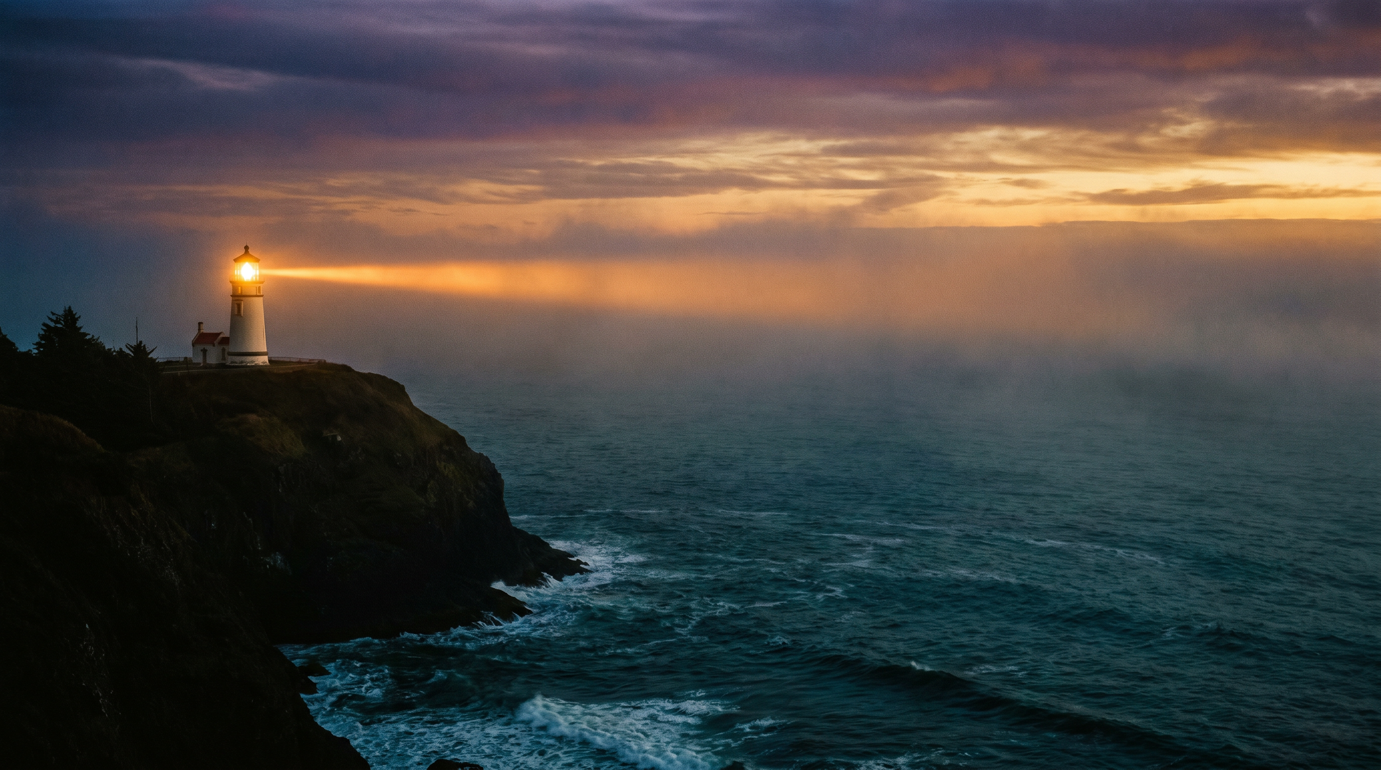 Heceta Head Lighthouse on the Oregon coast at dusk, a single disciplined beam of light cutting across dark Pacific water