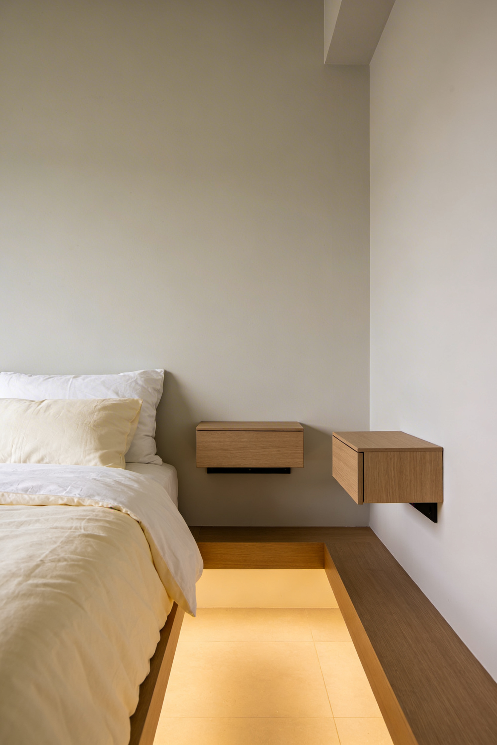 Tiny bedroom with floating wooden nightstands and light bedding in Scandinavian style